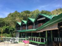Un edificio con techos verdes y una silla rosa. en Liberty's Lodge and Diving - Apo Island, en Dumaguete