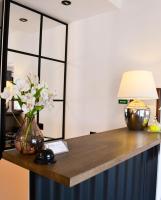 un escritorio con un jarrón de flores y una lámpara en Hotel Astra Tajemniczy Ogród, en Poznan