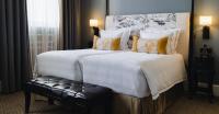 a large bed with white sheets and yellow pillows at The Gainsborough Bath Spa - Small Luxury Hotels of the World in Bath