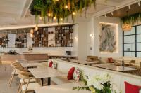 a restaurant with tables and chairs and a bar at Niranapa Boutique Resort in Kata Beach