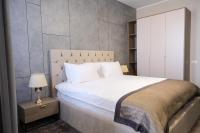 a bedroom with a large white bed and a lamp at Hotel Building Stefan Resort I in Mamaia Sat&#47;Năvodari