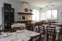a dining room with white tables and chairs and a fireplace at Agriturismo Villa Marta in Cesena
