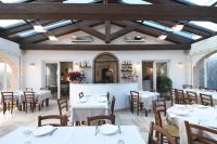 a dining room with white tables and wooden ceilings at Agriturismo Villa Marta in Cesena