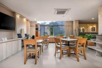 Un restaurante con mesas y sillas y un televisor. en Leblon Suites Hotel Milla de Oro, en Medellín