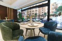 麦加TIME Ruba Hotel & Suites的一家餐厅，里面有桌椅和一扇大窗户。