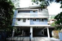 a white building with a fence in front of it at Greens in Kozhikode