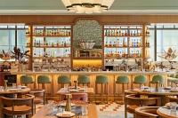 un restaurante con barra con mesas y sillas en Sutton Place Hotel Toronto, en Toronto