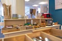 a counter with baskets of food and plates on it at Hôtel Arcadia in Lannion