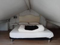 a white bed with a black bag on it at Maison de charme, plage a 300 m Dinard St Enogat in Dinard