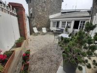 an outdoor patio with chairs and a table and plants at Maison de charme, plage a 300 m Dinard St Enogat in Dinard