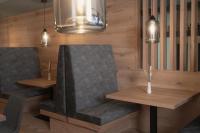 a dining room with two chairs and lights at Hotel Gamshag in Saalbach-Hinterglemm