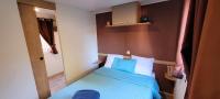 a small bedroom with a bed with blue sheets at Camping Aux Portes De Cassis in La Bédoule