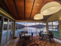 卡皮托利乌Hotel Boutique Coração Aberto的一间配备有桌椅的用餐室,享有水景