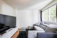 a living room with a couch and a tv at T4 spacieux tout confort &#47; parking gratuit in Grenoble