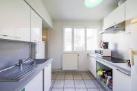 a kitchen with white cabinets and a sink and a window at T4 spacieux tout confort &#47; parking gratuit in Grenoble