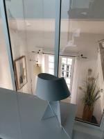 une lampe assise dans une pièce avec miroir dans l&#39;établissement Appartement cosy esprit loft, à Paris