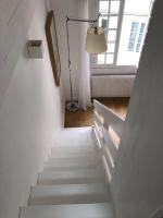 un escalier dans une chambre blanche avec une lampe et une fenêtre dans l&#39;établissement Appartement cosy esprit loft, à Paris