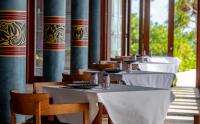 una fila de mesas y sillas con mantel blanco en Furaveri Maldives - COMPLIMENTARY ROUND-TRIP SEAPLANE TRANSFER FOR TWO FOR A MINIMUM OF 5 NIGHTS OR MORE FOR STAYS 1ST MAY 2026 TO OCTOBER 31ST 2026, en Raa Atoll