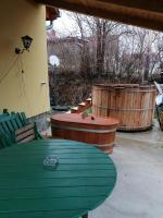 a patio with a green table and chairs and barrels at Berkenyés Vendégház in Zalalövő