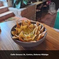 een schaal met chips en guacamole op een tafel bij Hotel CasaMia in Dolores Hidalgo