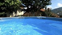 a large swimming pool with blue water in front of a house at Guest House Lejla in Travnik