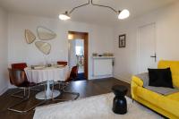 a living room with a table and a yellow couch at Calme, Confort et Propreté in Vittel