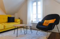 a living room with a yellow couch and a chair at Calme, Confort et Propreté in Vittel
