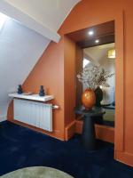 an orange room with a vase on a table at Calme, Confort et Propreté in Vittel