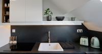 a kitchen with a sink and a black counter top at Calme, Confort et Propreté in Vittel