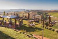 un restaurante con mesas y sombrillas en un campo en Glamping Diacceroni, en Villamagna