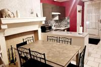 a kitchen with a dining table and a fireplace at Maison Jean Léone in Gevrey-Chambertin