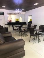 Un comedor con una mesa y sillas y una lámpara de araña. en Hotel Vila Real Dourados, en Dourados