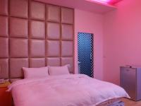 a bedroom with a large bed with pink walls at Foot Track Bed and Breakfast in Hualien City