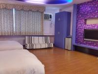 a hotel room with two beds and a purple wall at Foot Track Bed and Breakfast in Hualien City