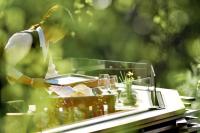 Una mujer está sentada en una mesa con vasos. en Park Hotel Sonnenhof - Relais & Châteaux, en Vaduz