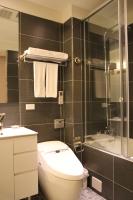 a bathroom with a toilet and a shower and a sink at Capital Hotel SongShan in Taipei