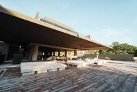 ein Gebäude mit Bänken und Tischen auf einer Terrasse in der Unterkunft The Funny Lion - Puerto Princesa in Puerto Princesa