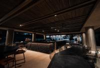 eine Terrasse mit Tischen und Stühlen sowie eine Bar in der Unterkunft The Funny Lion - Puerto Princesa in Puerto Princesa