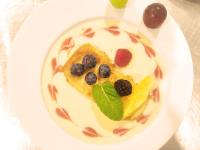 a white plate with a dessert with fruit on it at Teatrisso Hotel Palacio in Cuzcurrita-Río Tirón
