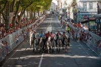 a group of people riding horses down a city street at Hôtel du Champs de Mars in Béziers