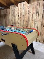 a foosball table in a room with a wooden wall at Maison piscine &amp; spa Vallon Pont d&#39;Arc in Vallon-Pont-dʼArc