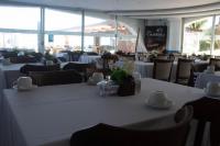 ein Esszimmer mit weißen Tischen und Stühlen in der Unterkunft New Casablanca Praia Hotel in Paulista
