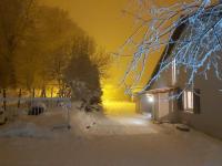 einen schneebedeckten Hof mit einem Haus in der Nacht in der Unterkunft La Loge des Volcans - Vue Puy De Dôme in Saint-Genès-Champanelle