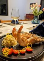 Un plato de comida con camarones y verduras en una mesa. en CASA ROMA Hotel Boutique, en El Tamarindo