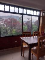 Una mesa y sillas en una habitación con una ventana grande. en Monte Gocta, en Valera
