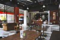 un ristorante con tavoli, sedie e un divano di The Swarna Hotel Bayah Lebak a Muaramadur