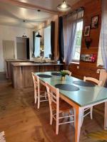 a dining room with a table and chairs and a kitchen at Appart. spacieux et lumineux 4 pers. in Morez