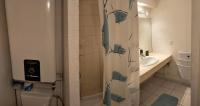 a bathroom with a shower curtain with a toilet and a sink at La Terrasse du Vénus - Port Vendres in Port-Vendres