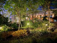 Bangnu Greenery Resort في Takua Thung: حديقة في الليل مع أضواء في مبنى