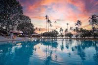 Una piscina con palmeras y una puesta de sol. en Pegasus Reef - A Beach Resort in Colombo, en Colombo